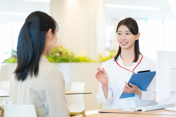 Fototapeta premium 病院で打ち合わせをする若い医者 撮影協力：学校法人電波学園東京電子専門学校