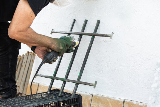 Man uses angle grinder on DIY project.