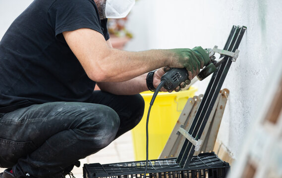 Using angle grinder to remove rust from old metal security gate