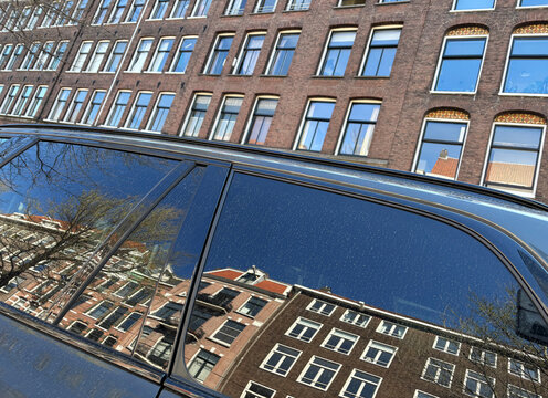 facade of buildings reflected in car window