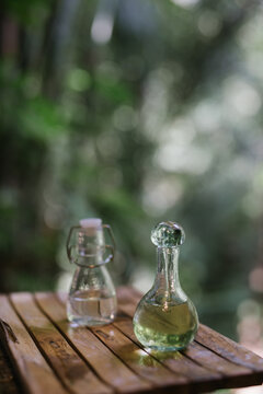 Glass Bottles with Essential Oils on Wooden Tray in Tropical Setting