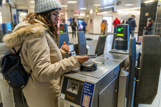 woman using smartphone to pay subway ticket 