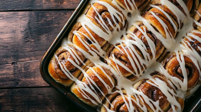 Freshly baked cinnamon rolls in a metal pan.