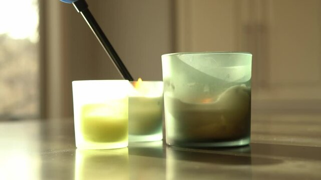 Close up candle being lit long black lighter reflective surface shallow depth