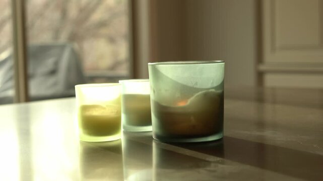 Smoke rising from extinguished frosted glass candle on table blowing out candles