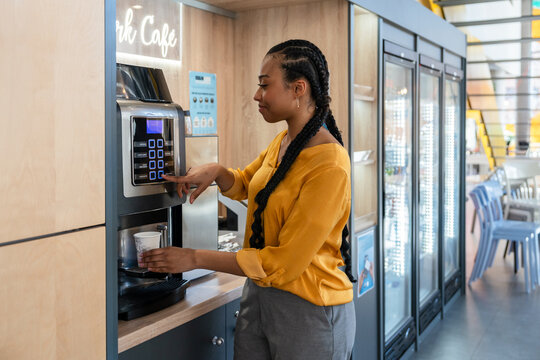 Woman using a coffee machine in a modern office