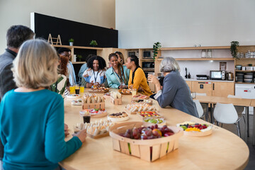 Diverse group enjoying a casual office catering lunch gathering