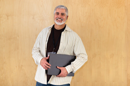Smiling professional holding laptop in striped shirt