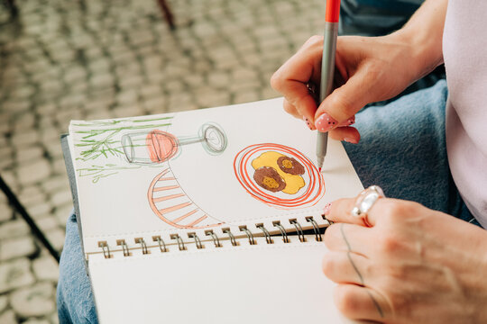 Coloring plate of food sketch in spiral notebook at cafe
