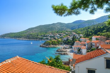 Obraz premium Coastal town nestled in a bay. Houses with terracotta roofs overlook turquoise water