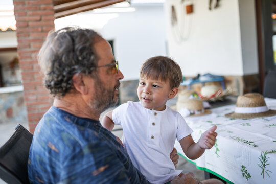 Grandfather and grandson sharing a summer meal on the porch