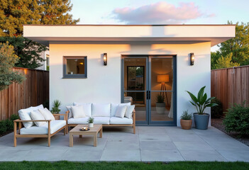 Design your modern living space with a sleek white modular unit opening onto a paved patio furnished with contemporary outdoor seating, perfect for a stylish backyard office, studio,