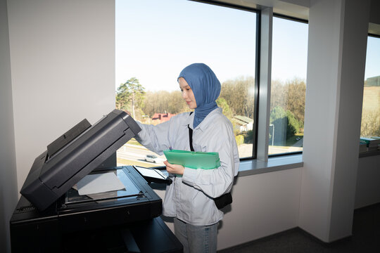 Woman Wearing Hijab Using Office Copier


