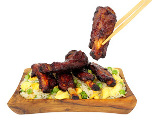Mini Chinese barbecue mini pork ribs with egg fried rice in a olive wood serving dish isolated on a white background
