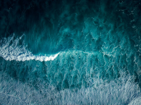 Top down aerial view of moody blue ocean wave