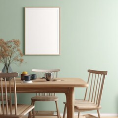A minimalist dining room features a light-green wall, wooden table with chairs, a simple frame, dried flowers in a vase, and ceramic mugs