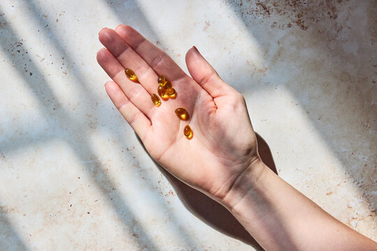 Female hand holding a bunch of fish oil pills