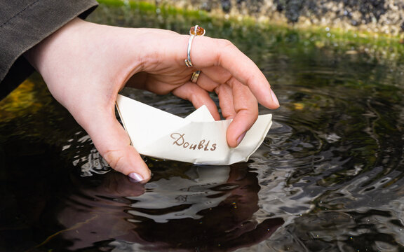 Taking a paper boat near the water