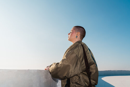 Person in bomber jacket enjoying peaceful seaside view