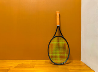 One Tennis racquet with orange grip 