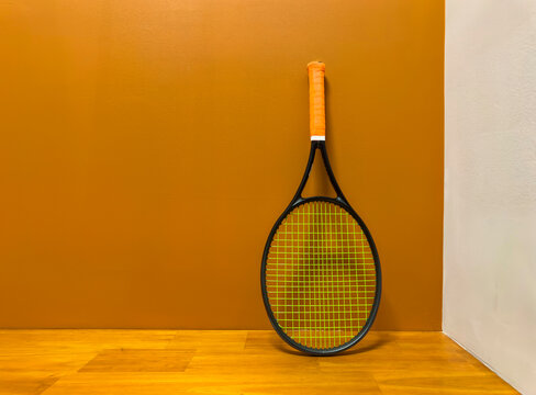 One Tennis racquet with orange grip 