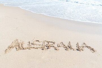 The word Australia written in the white beach sand