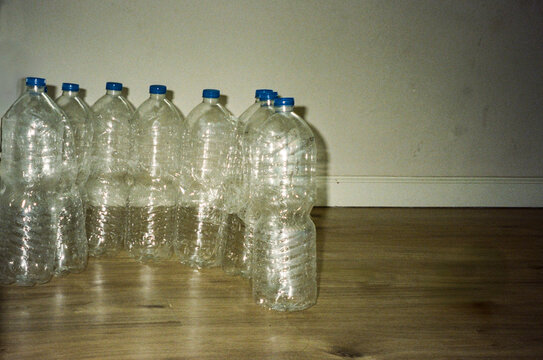 Row Of Empty Reusable Plastic Bottles On Wooden Floor.Analog film phot