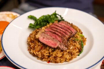 Stir-fried Basil with Rare beef steak served on plate. It is a popular Thai dish known as Pad Kra Pao
