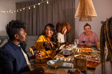Diverse friends enjoying a cozy dinner gathering at home