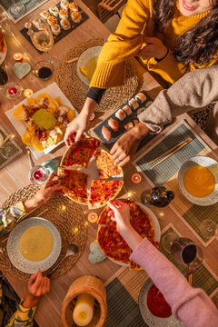 Sharing pizza and dishes at a joyful dinner gathering