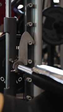 Vertical slowmotion shot of an athlete reracking the barbell after doing hip thrusts
