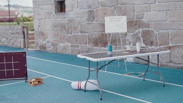 blue court with table games cups sign and tic tac toe board