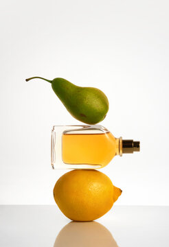 Fresh fruit and blank perfume bottle with yellow liquid still life. 