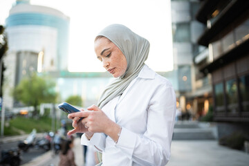 Young professional engaging with smartphone outdoors