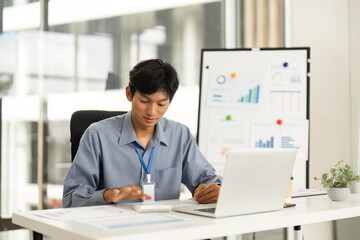 Obraz premium Productive Workspace. Young man using smartphone while working on laptop.