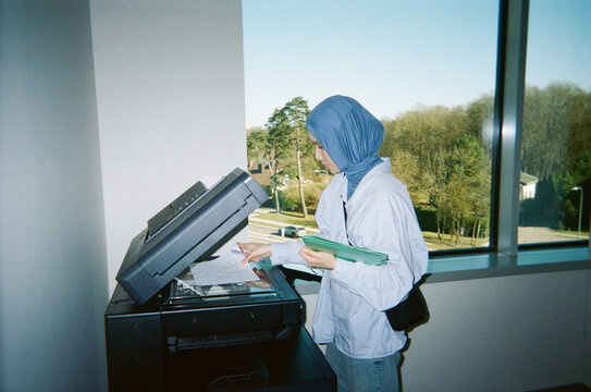 Woman Wearing Hijab Using Office Copier

