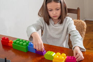 child with autism lines up colorful toy blocks