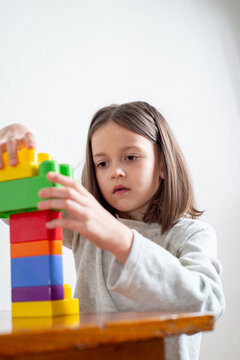Child with autism without eye contact builds a tower of toy blocks