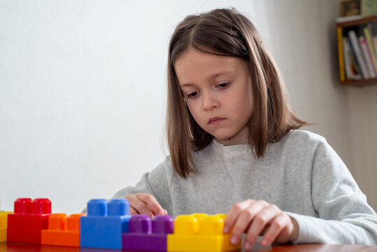 child with autism lines up colorful toy blocks