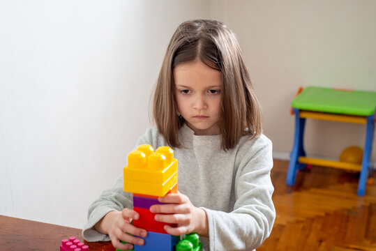 child with autism lines up colorful toy blocks