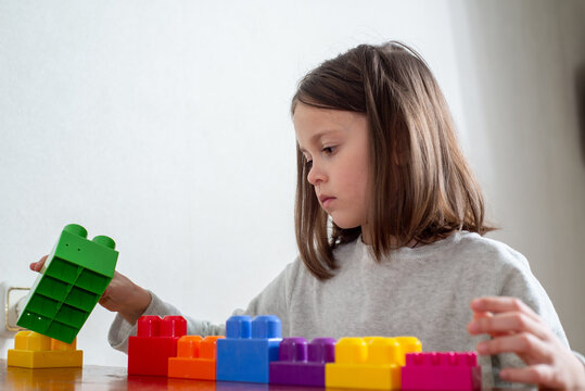 child with autism lines up colorful toy blocks