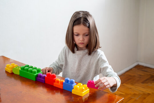 child with autism lines up colorful toy blocks