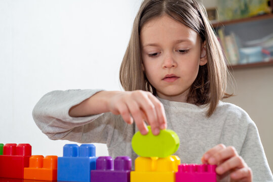 child with autism lines up colorful toy blocks