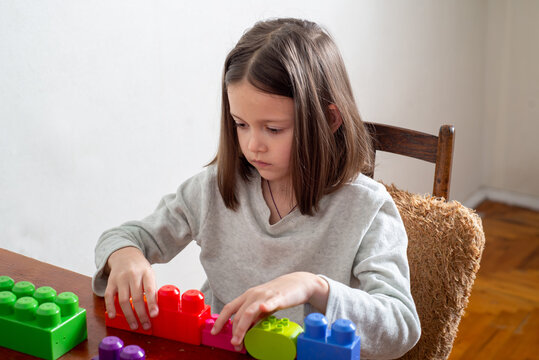 child with autism lines up colorful toy blocks