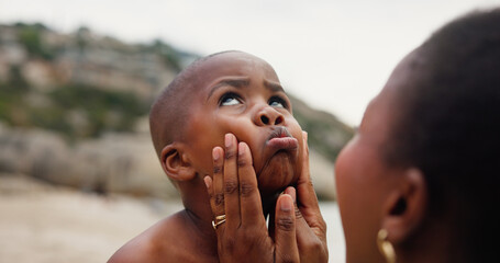 Black family, child and beach with mother for sunscreen, safety or outdoor UV protection in nature. Kid, son and mom with face for SPF, skincare or love together for childhood on ocean coast or sea © peopleimages.com