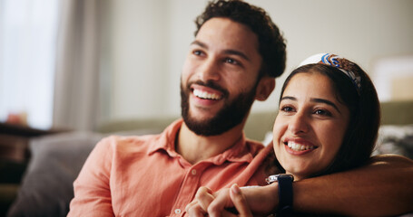 Couple, happy and watching tv on sofa with hug, relax and bonding with movie in living room at...
