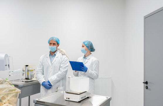 Scientists Analyzing Rat In Non-Invasive Behavioral Study Lab