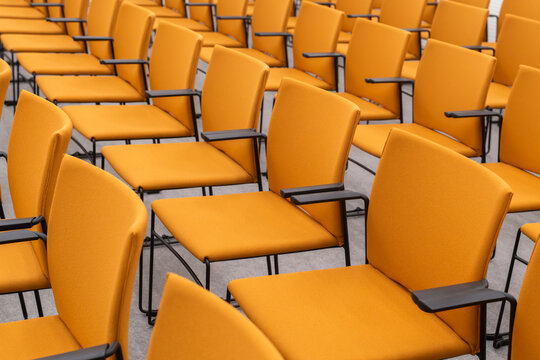 Rows Of Empty Orange Color Chairs Indoors