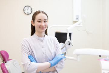 Portrait of female dentist. She's standing in her dentist office.