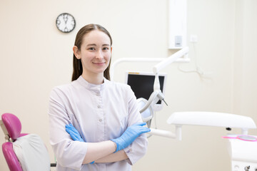 Portrait of female dentist. She's standing in her dentist office.